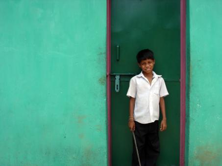 Free Stock Photo of Boy infront of green door