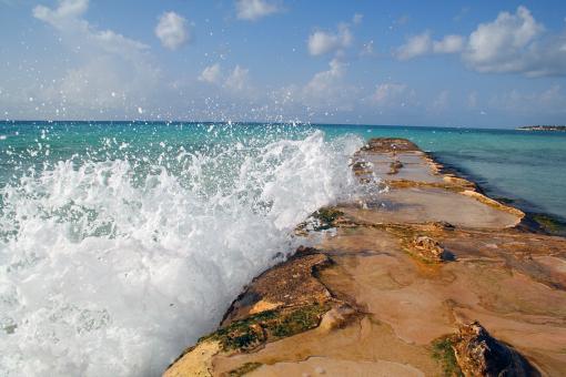 Free Stock Photo of Water breaking over a seaside barrier