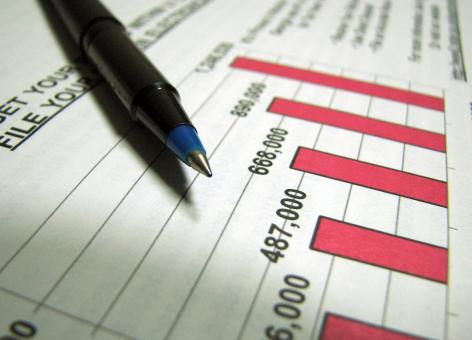 Free Stock Photo of Closeup of a tax income graph and pen