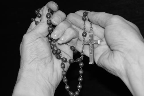 Free Stock Photo of Holding a Cross on String of Beads - Black & White