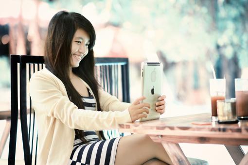 Free Stock Photo of Smiling Lady using IPad