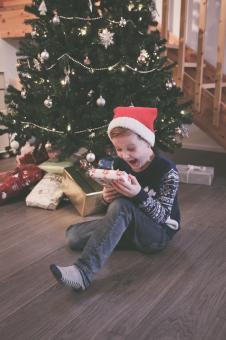 Free Stock Photo of Excited Boy Opening His Christmas Presents