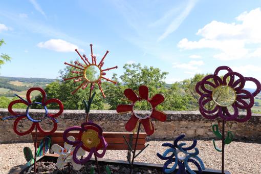 Free Stock Photo of Various iron colored flower sculptures in a street