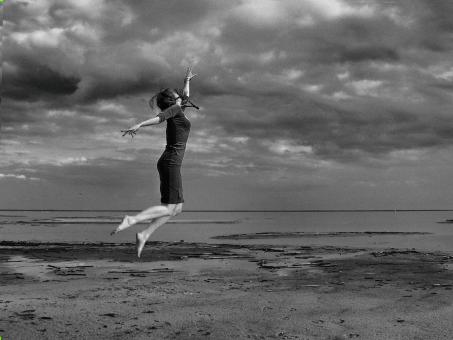 Free Stock Photo of Girl Jumping on the Beach - Black and White
