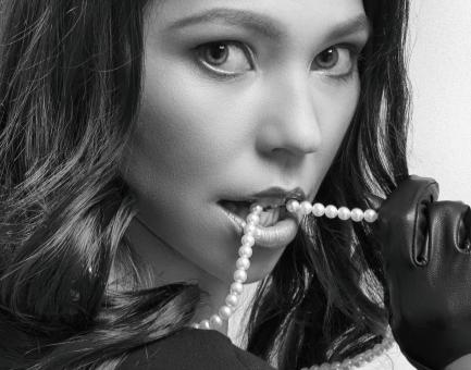 Free Stock Photo of Girl Biting Pearl Necklace - Monochrome Portrait
