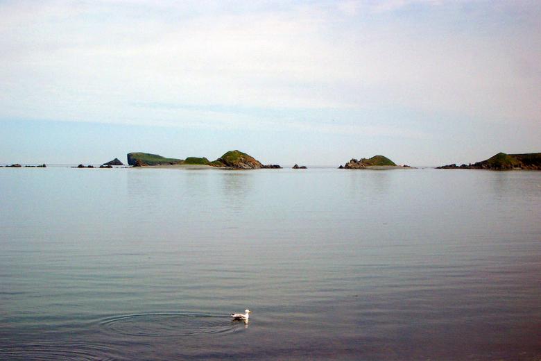 Free stock image of Open water with some rocks in the distan created by damien van holten