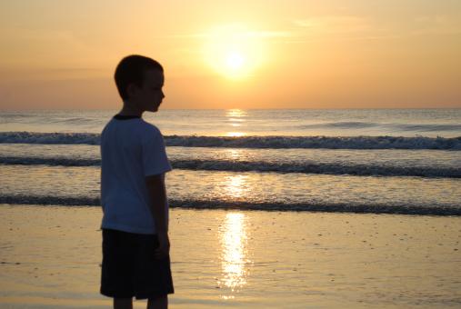Sunrise at beach with boy - Free Stock Photo