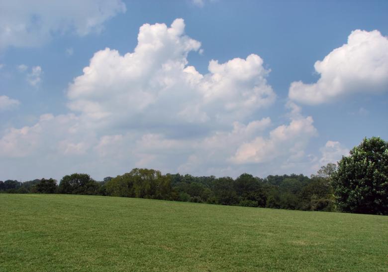 Free stock image of A large grass field with a blue sky created by Benjamin Miller