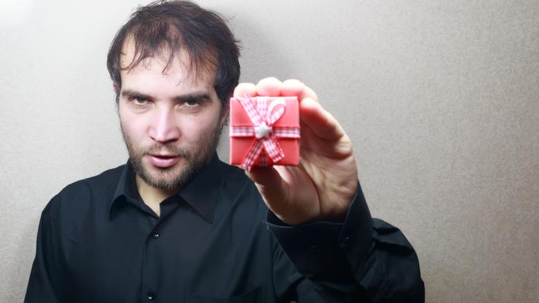 Free stock image of young man holding a gift  created by Mudretsov Olexandr