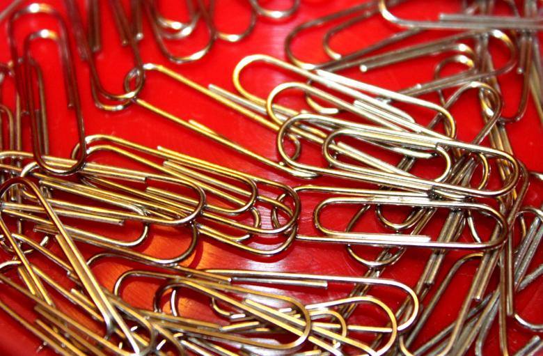 Free stock image of Metallic paperclips on red background created by NomeVizualizzato