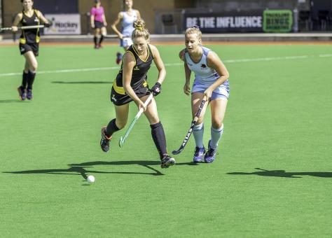 Field hockey game two women battle for control of ball