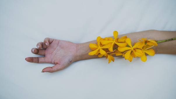 A Woman With Yellow Flowers On Her Arm