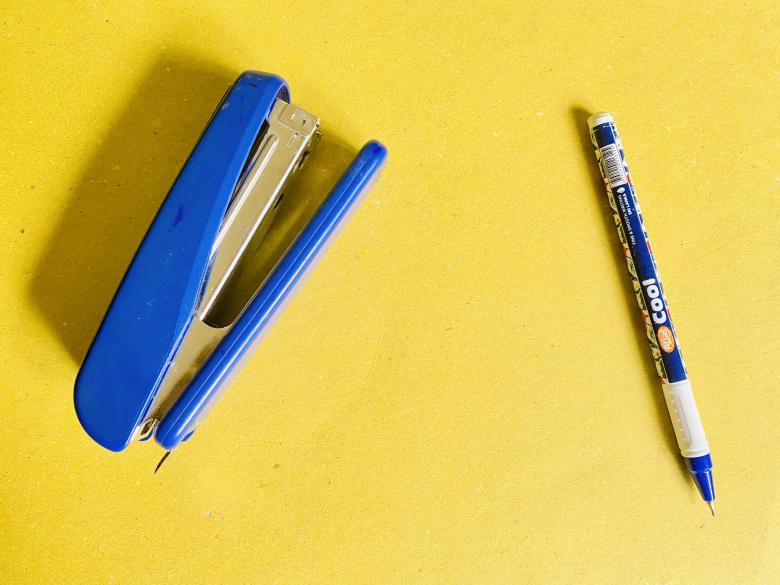 Free stock image of A blue pen and a blue stapler on Yellow background  created by SK