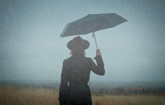 Woman Walking Alone in the Rain - Loneliness Concept