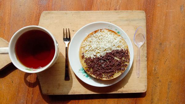 A mini photo of a martabak with a chocolate topping and grated c