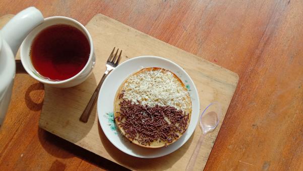 A mini photo of a martabak with a chocolate topping and grated c