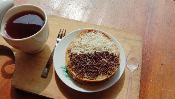 A mini photo of a martabak with a chocolate topping and grated c