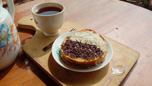 A mini photo of a martabak with a chocolate topping and grated c