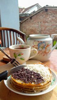 A mini photo of a martabak with a chocolate topping and grated c