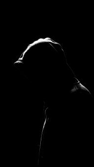 A Silhouette of a Person with Backlit Hair and a Dark Background Showi